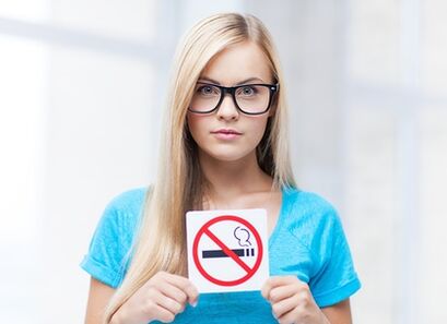 fille avec un panneau interdisant de fumer à l'entrée